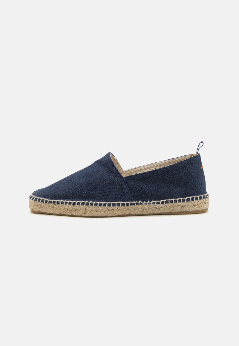 Navy canvas slip-on shoe with a jute rope sole, low vamp, and subtle stitching details. Features a looped heel tab for easy wear.