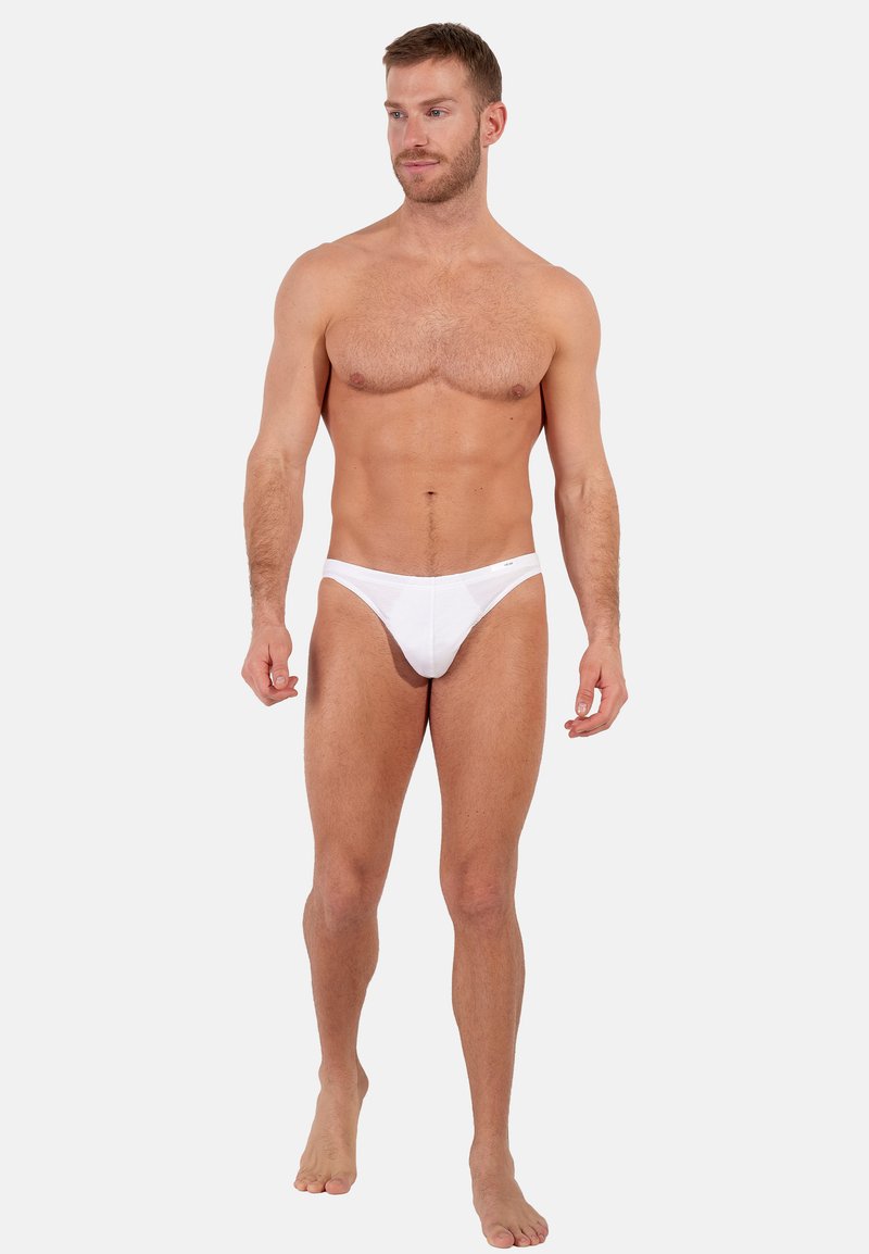Weiße Herren-Tanga-Unterwäsche aus weichem Stoff, mit passgenauem Design und minimalistischem Stil, der einen leichten Glanz aufweist.