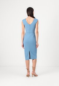 Vestido azul justo com mangas curtas, costas em V, comprimento até o joelho e uma fenda nas costas. Feito de tecido suave, com um fecho de correr oculto.