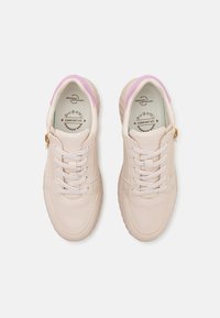 Zapatilla de color rosa claro con parte superior de cuero texturizado, cierre frontal de cordones, detalle de cremallera dorada y forro interior suave. Presenta una punta redondeada.