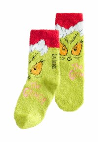 Jasnozielone, puszyste skarpety z czerwonymi ściągaczami, z wkurzonymi żółtymi oczami Grincha oraz napisem "Grinch" w kolorze różowym.