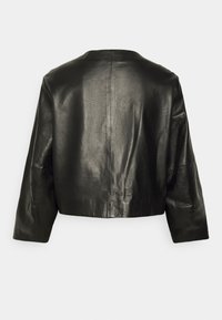 Černá kožená zkrácená bunda s hladkým povrchem, kulatým výstřihem a širokými rukávy. Má centrální šev na zádech.
