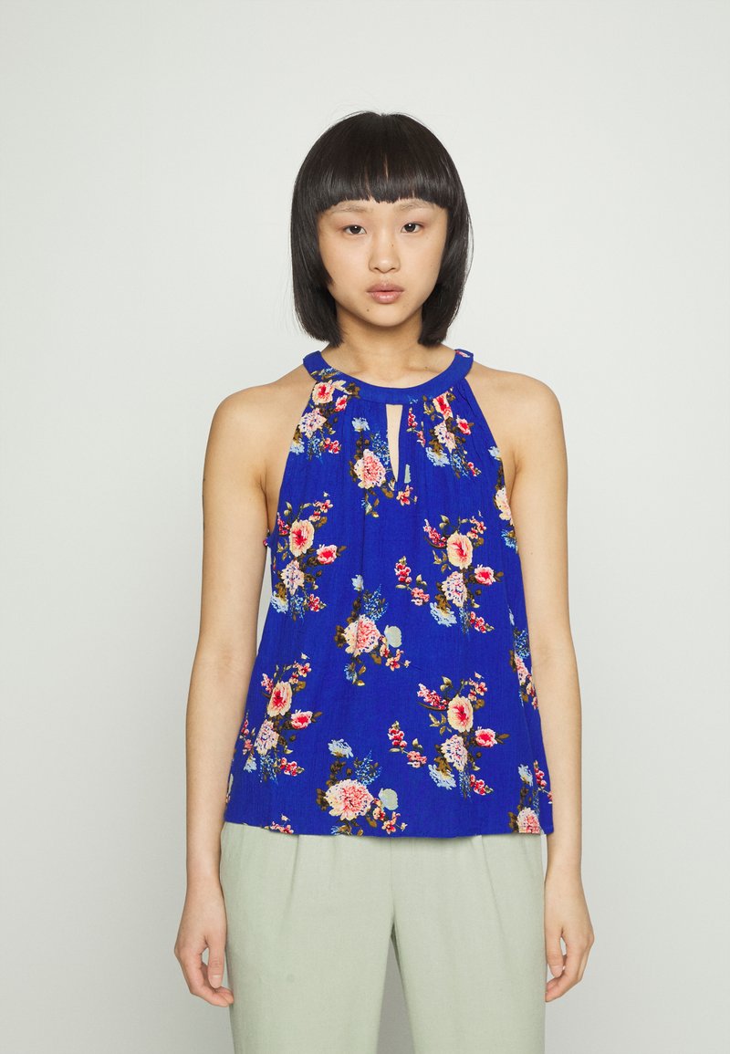 Top de tiras azul com um detalhe em forma de buraco na gola, apresentando padrões de flores multicoloridas e um tecido suave e leve.