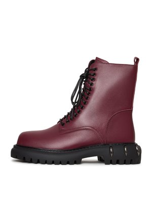 Botine din piele burgundă, cu șireturi negre, talpă groasă din cauciuc negru și vârful rotund. Prezintă un panou lateral texturat și accente metalice.