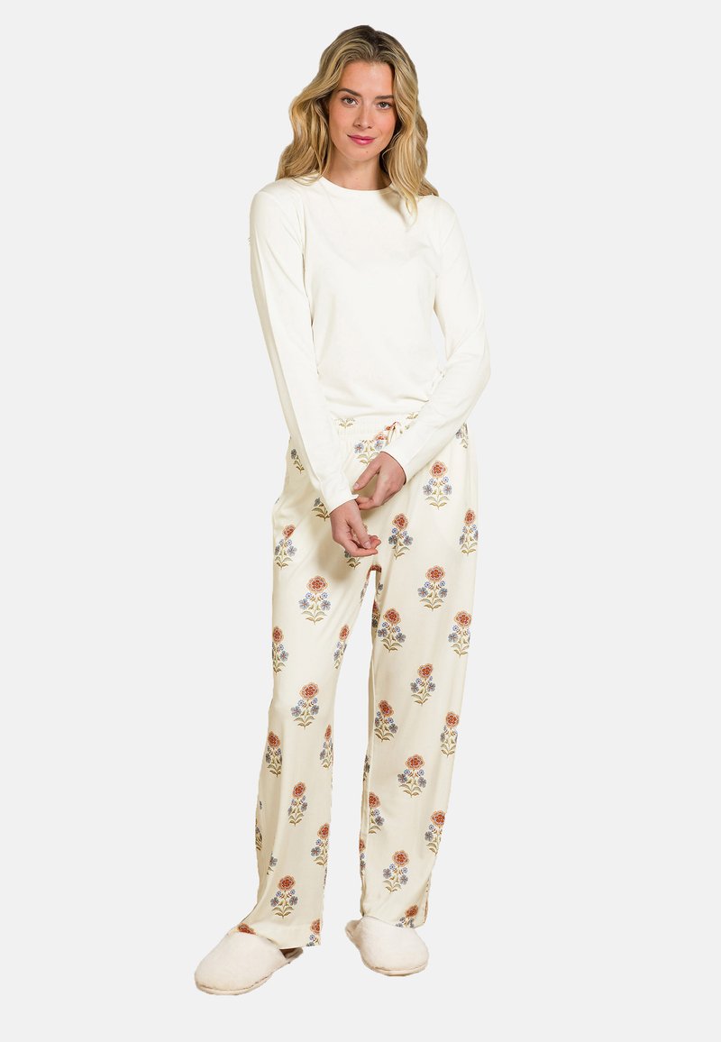 Lightweight cream long-sleeve top paired with patterned pajama pants featuring floral designs in orange, blue, and green. Soft, comfortable fabric.