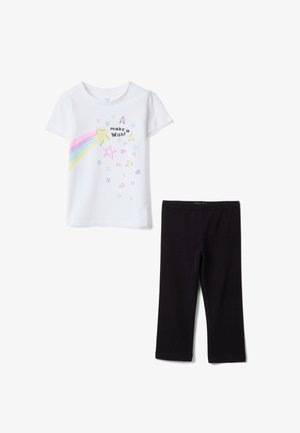 T-shirt blanc à manches courtes avec des étoiles colorées, un arc-en-ciel et le texte « fais un vœu ! », associé à des leggings noirs unis.