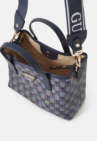 Borsa a motivo blu realizzata in materiale sintetico, con logo dorato, due manici e tracolla regolabile. L'interno è foderato di beige.