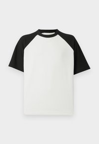 Lyhythihainen musta-valkoinen t-paita, jossa on ribbikuvio; ominaisuuksina raglan-hihat ja pyöreä kaula-aukko.