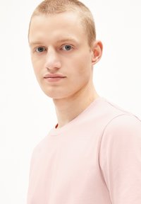 Lichtroze crewneck t-shirt van zacht materiaal, met korte mouwen en een eenvoudig ontwerp, met een gladde, gelijkmatige textuur.