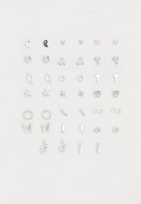 Set aus silbernen Ohrringen mit verschiedenen Formen: Sterne, Herzen, Kreuze und Symbole wie Schlangen und Schmetterlinge, mit einer Mischung aus Texturen und Oberflächen.