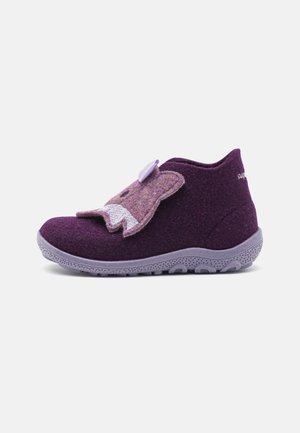 Chausson pour enfants violet avec semelle grise, doté d'un rabat en forme d'ourson avec des détails du visage cousus pour la fermeture.