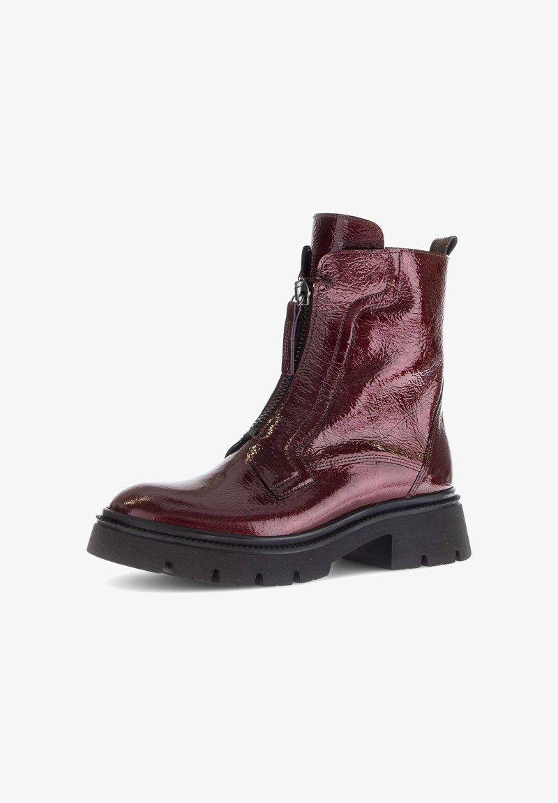 Burgundy ankle boot with a glossy finish, side zipper, thick black rubber sole, and textured leather design.