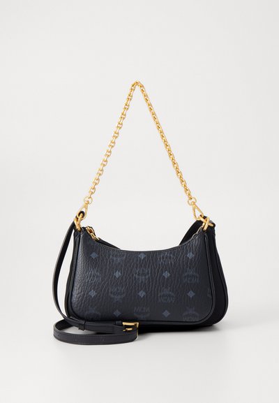 Černá kožená kabelka přes rameno se zlatým řetízkem a nastavitelným koženým popruhem, s vyraženými logy MCM a diamantovými vzory.