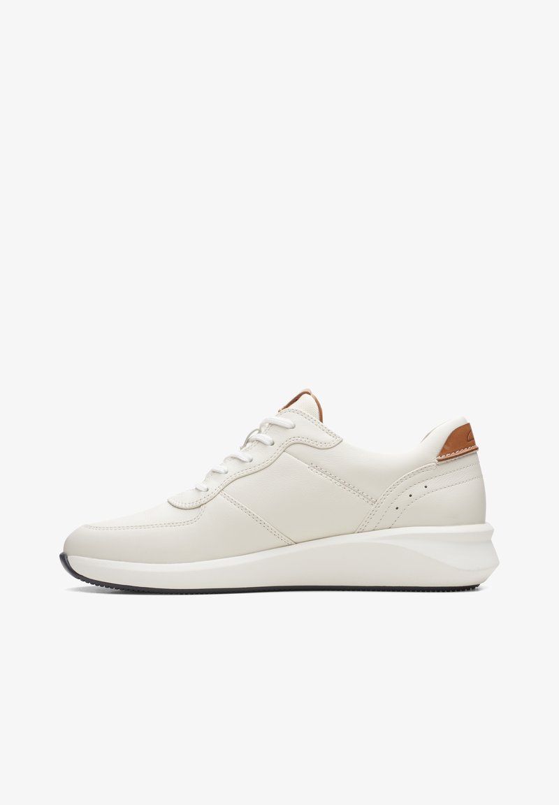 Baskets en cuir blanc avec languette de talon marron clair, fermeture à lacets sur le devant et semelle épaisse blanche avec bande de roulement noire, vues de profil.