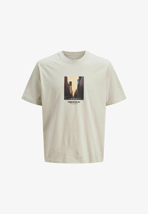 Krém színű, rövid ujjú pamut póló, amelyen egy téglalap alakú városi grafika és alatta a "Originals Studio" felirat található.