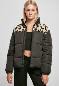 Donsjack in donkergrijs met een beige fleece luipaardprint op de schouder. Voorzien van een geborduurd patroon, hoge kraag en een rits aan de voorkant.