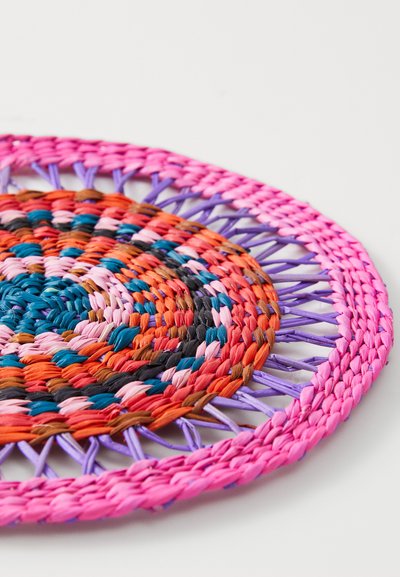 Round woven placemat in vibrant colors of pink, orange, blue, and purple. Features intricate braiding and a circular design.