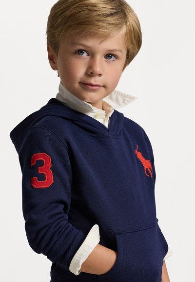 Sudadera azul marino con bordado rojo que presenta el número "3" en la manga y un logo en el pecho. Material de algodón con un acabado texturizado.