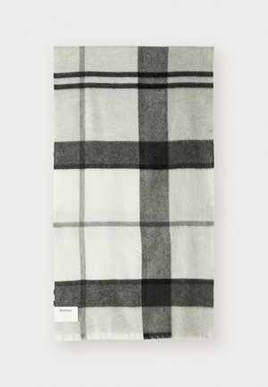 Couverture à carreaux gris et blancs avec une texture douce, de forme rectangulaire et une petite étiquette de marque sur un bord.