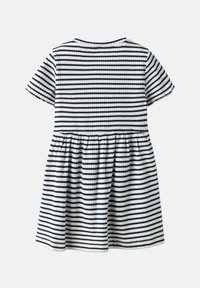 Sukienka w paski charakteryzuje się granatowo-białymi poziomymi paskami, krótkimi rękawami, ribbową teksturą oraz rozkloszowanym dołem opadającym od talii.