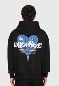 Person wearing black hoodie with a blue heart-shaped balloon graphic and white text "DROPSIZE HYPE LASTS FOREVER" on the back.