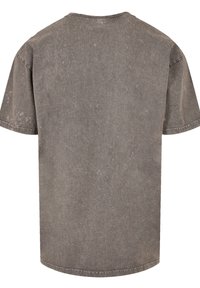 Graues T-Shirt mit kurzen Ärmeln aus strukturiertem Stoff, der deutliche Verfärbungen aufweist, mit rundem Halsausschnitt und geradem Saum.