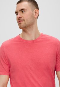 Kurzärmliges T-Shirt in Koralle, aus weicher Baumwolle gefertigt, mit Rundhalsausschnitt und komfortablem Schnitt sowie glatter Oberfläche.