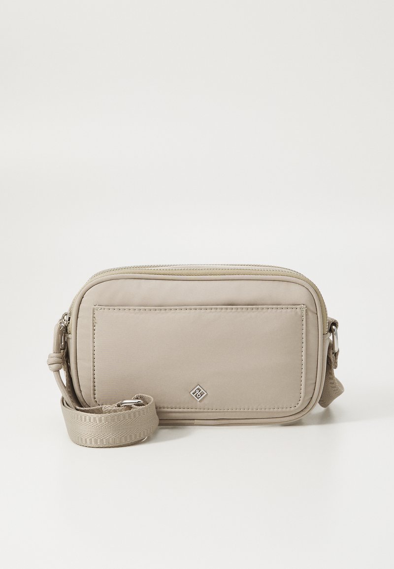 Beige crossbody bag with a smooth nylon exterior, zip closure, adjustable strap, and a front pocket featuring a subtle logo detail.