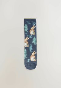 Chaussettes navy avec un motif de lapins et d'arbres dans des couleurs pastel. Fabriquées en tissu doux avec un bord côtelé et une pointe arrondie.