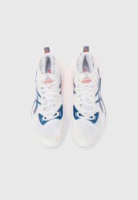 Witte sportschoenen met blauwe accenten, een getextureerde mesh bovenkant, flexibele zool en rode details op de hak en het logo.