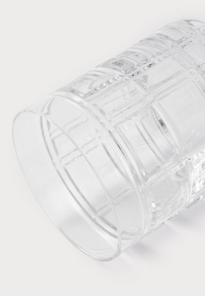 Caurspīdīgs stikla glāze ar reljefu ģeometrisku rakstu, gludu virsmu, cilindrisku formu un pulētu malu.