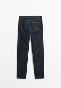 Jeans in denim blu scuro con taglio dritto, dotati di cinque tasche e cuciture a contrasto. La parte posteriore presenta due tasche di forma quadrata.