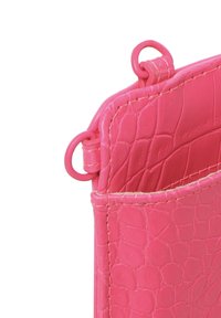 Borsa in pelle rosa con texture a rilievo effetto coccodrillo. Presenta due anelli metallici nella parte superiore per attaccare una tracolla. Bordo arrotondato, design minimalista.