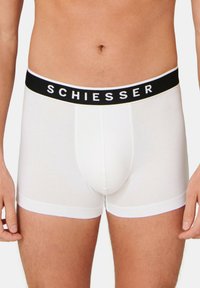 Valkoiset бокserit, joissa on musta joustovyö, jossa on "SCHIESSER"-logo. Silkkinen pinta, istuva muotoilu, mid-thigh-pituus.