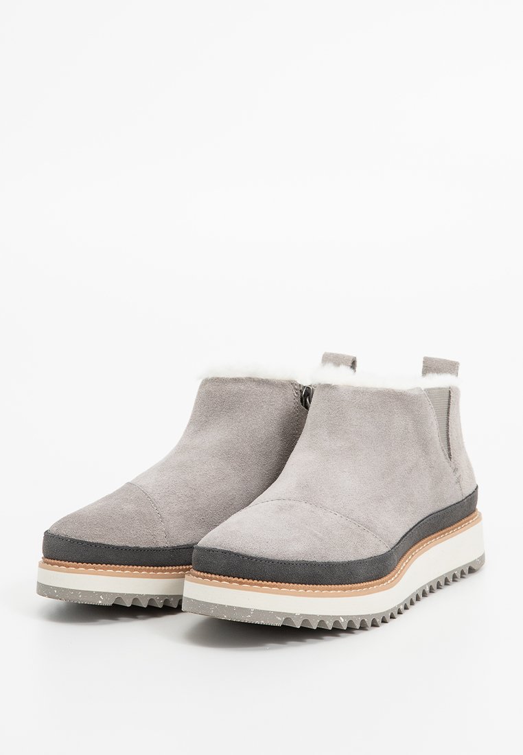 Grå mockaimitation ankle boots med en texturerad mellansula, utrustade med en fluffig foder, en dragkedja på sidan och en robust, kontrasterande yttersula.