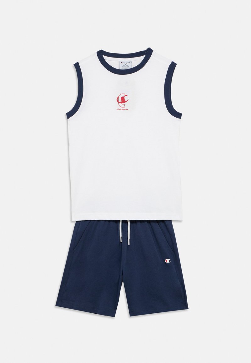 Λευκό αμάνικο τοπ με ναυτικό περίγραμμα και κόκκινο λογότυπο· συνδυασμένο με ναυτικό σορτς με ελαστική μέση και πλαϊνές τσέπες.