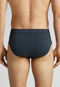 Donkerblauwe zwembroek gemaakt van rekbaar materiaal, met een lage tailleband en een strakke pasvorm, geschikt voor zwemmen en sportieve toepassingen.