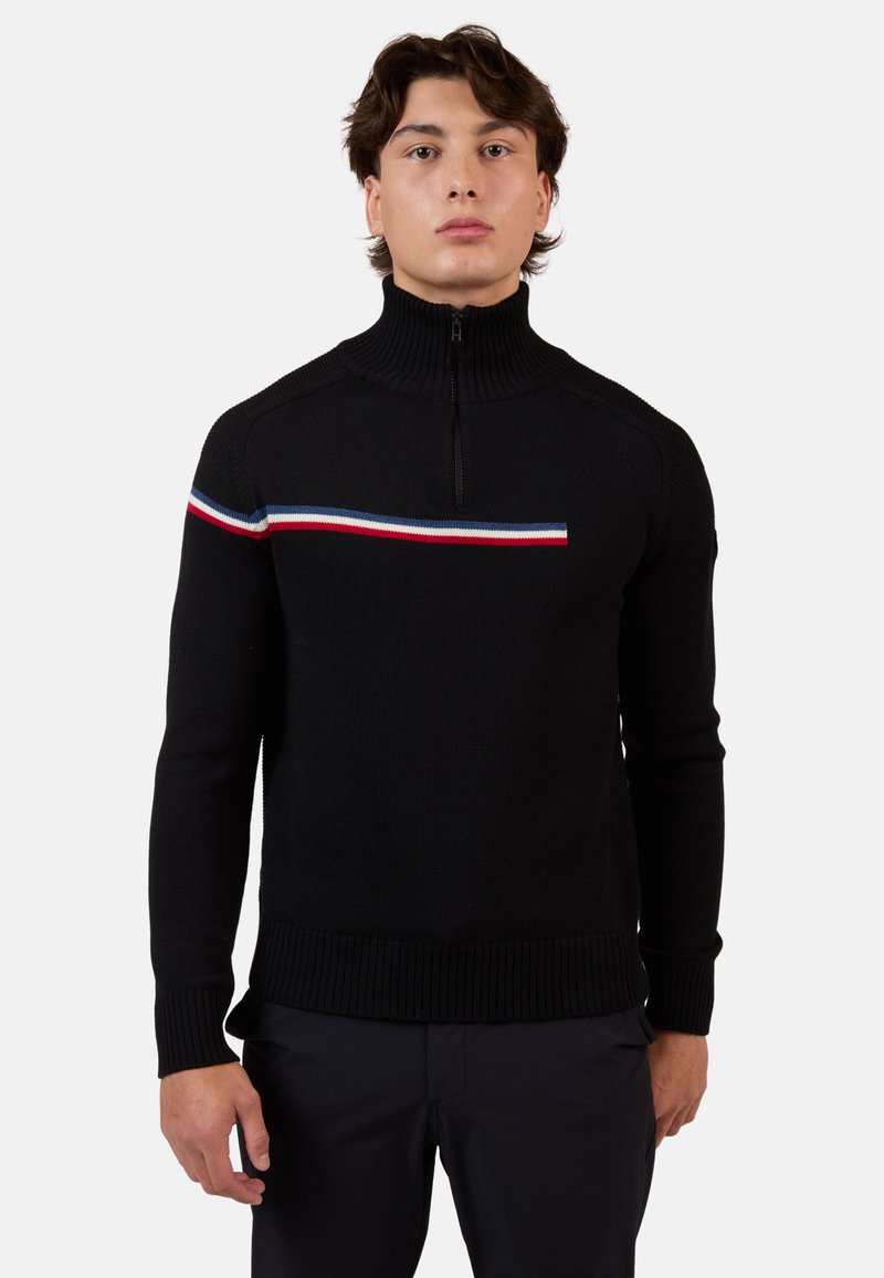 Schwarzer Strickpullover mit hohem Kragen und halbem Reißverschluss. Horizontale Streifen in Rot, Weiß und Blau über der Brust. Gerippter Saum und Bündchen.