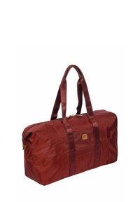 Sac de sport en nylon rouge avec deux poignées, une fermeture éclair et un patch logo en cuir marron à l'avant, présentant une finition texturée.
