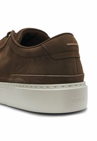 Dunkelbraunes Lederhalbschuh mit weißer Gummisohle, ausgestattet mit dezenten Nähten und geprägtem Markennamen auf der Ferse.
