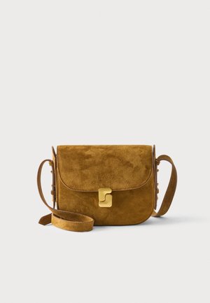 Bruine suède crossbodytas met goudkleurige sluiting en verstelbare riem op een effen lichte achtergrond.