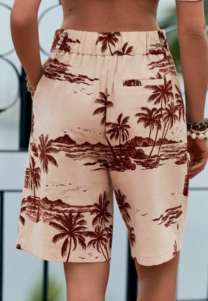 Pantaloni scurți bej cu imprimeu tropical maro închis cu palmieri și insulă, talie elastică, buzunar posterior, purtați de o persoană care stă cu mâinile pe lângă corp.