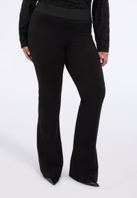 Černé rozšířené kalhoty se širokým, strukturovaným pasem. Vyrobeny z hladké tkaniny s elegantním, štíhlým střihem.