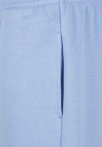 Hellblaue Jogginghosen aus weichem Baumwollmaterial, mit einem elastischen Bund und einer seitlichen Tasche für zusätzlichen Komfort.
