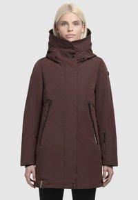Bordeaux geïsoleerde jas heeft een hoge kraag en voorzakken met rits. Gemaakt van glad materiaal met een knoopdetail op de kraag.