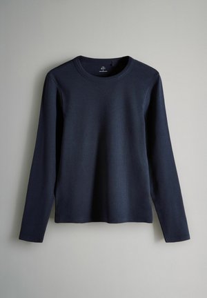 Sametöödega navy sinine pikakä sleeves t-särk, mis on valmistatud siledast kangast, ümmarguse kaelusega ja otse alläär. Lihtne disain, ilma lisamuster ja aktsentideta.