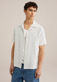 Short-sleeve shirt in white with thin blue stripes, featuring a collared neckline, button front, and relaxed fit, made of a lightweight material.
