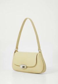 Žltá kožená kabelka s oblým tvarom, plochou chlopňou, strieborným kovaním a ramenným popruhom. Prešívanie pozdĺž okrajov.