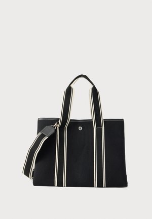 Sort lærreds-taske med dobbelte creme-stribede håndtag og matchende aftagelig skulderrem mod en ensartet lys baggrund.