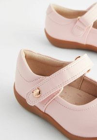 Rosa läder Mary Jane-skor med rund tå, innertextur i mocka, justerbar rem och en rosaguld kattformad knappdetalj.